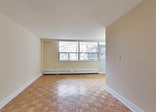 A room with wooden flooring and a window.
