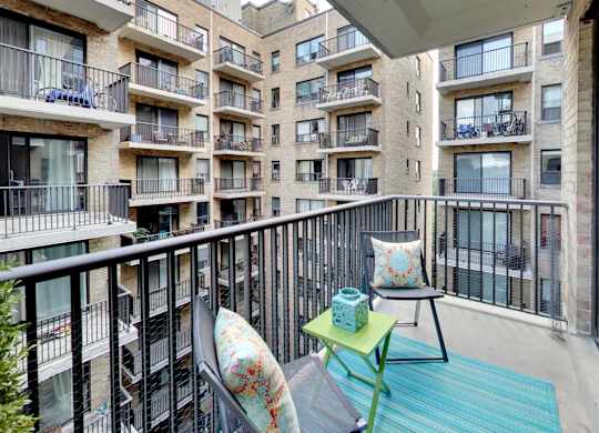 a balcony with two chairs and a table on a balcony
