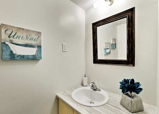 A bathroom with a white sink and a mirror.