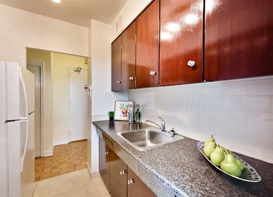 A kitchen with brown cabinets and a white refrigerator.