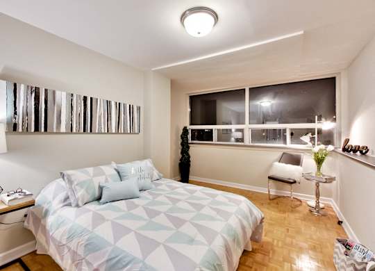 a bedroom with a bed and a desk and a window