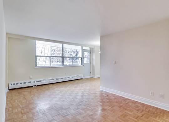 A room with a window and a radiator on the floor.
