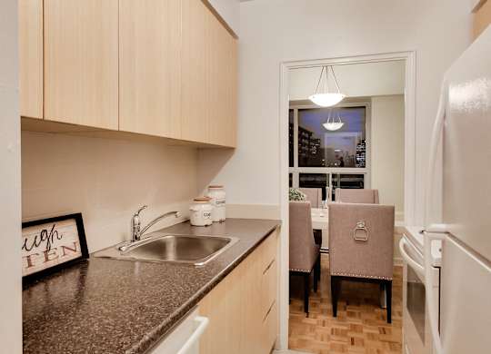 A kitchen with a sink, a fridge, and a window.