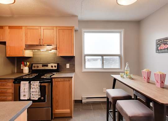 a kitchen with wooden cabinets and a table with chairs