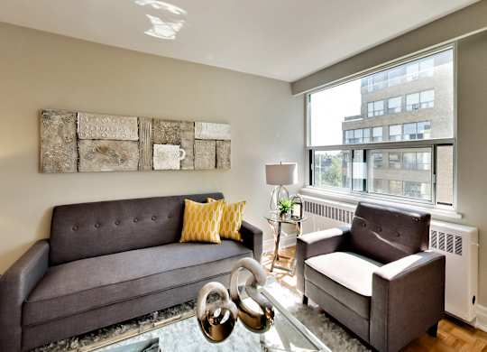 a living room with a couch and chairs and a large window