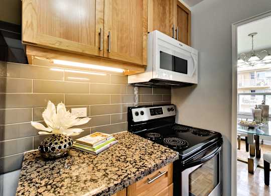 a kitchen with a granite counter top and a stove and microwave