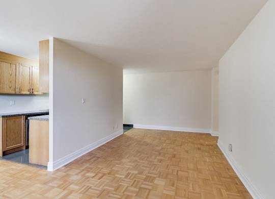 A room with wooden flooring and white walls.