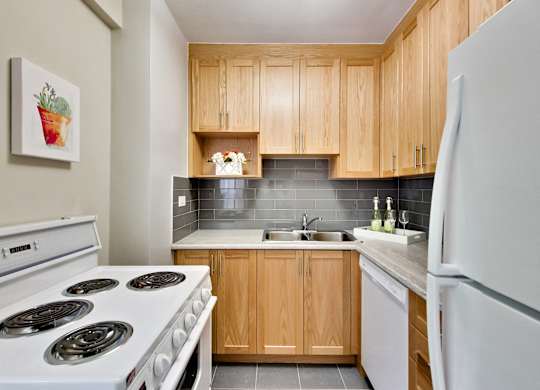 a kitchen with white appliances and wooden cabinets