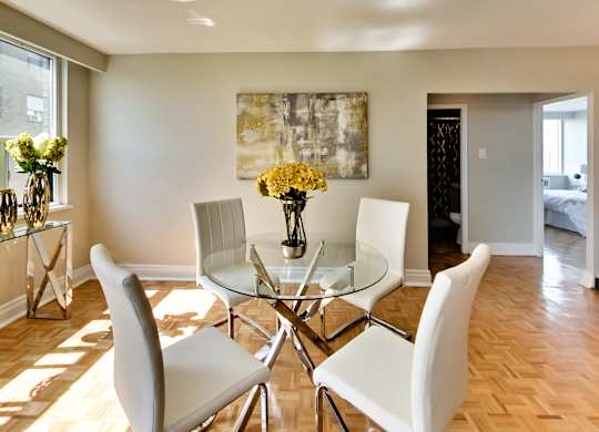 a dining room with a glass table and white chairs
