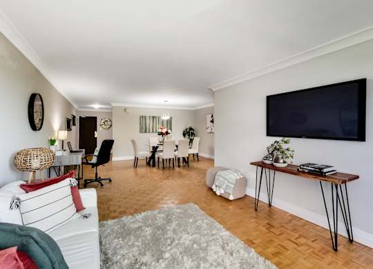 A living room with a white couch and a wooden floor.