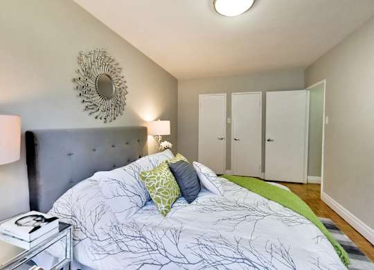 a bedroom with a large bed and a mirror on the wall