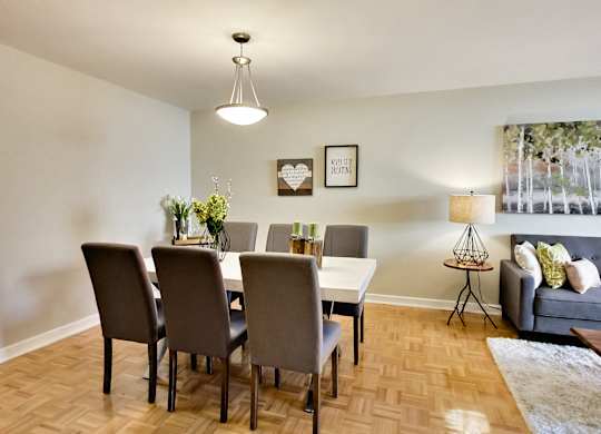 A dining room with a table and chairs.