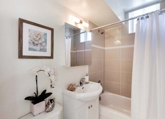 A white bathroom with a white sink and a white bathtub.
