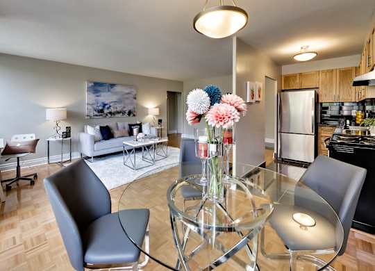 a living room and dining room with a glass table and chairs