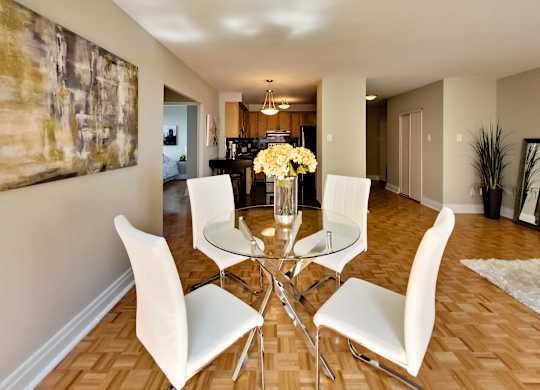 a dining room with a glass table and white chairs