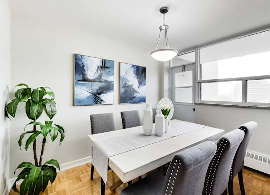 a dining room with a white table and chairs and a large window