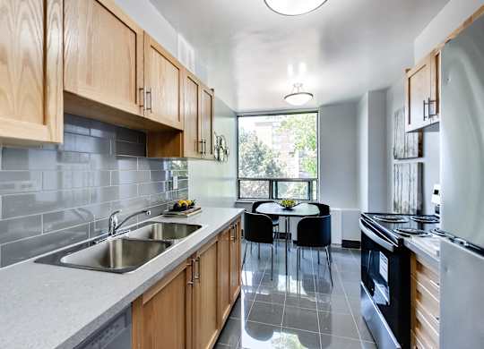 A modern kitchen with wooden cabinets and a large window.