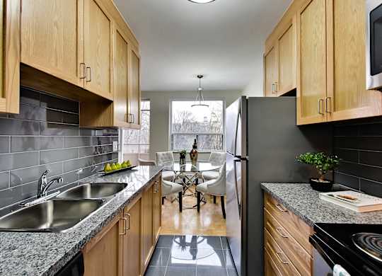 a kitchen with wooden cabinets and granite counter tops and a dining room with a table
