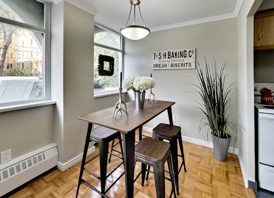 A kitchen with a table and chairs and a sign on the wall.
