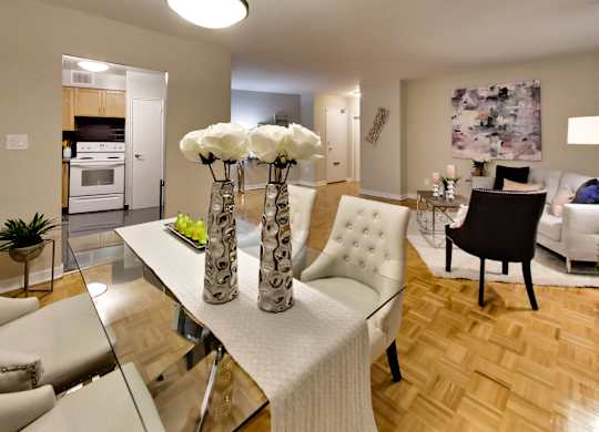 a view of a living room and dining room with a table with three vases