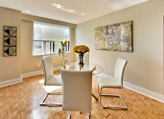 a dining room with a table and chairs and a window