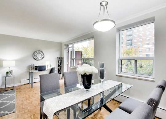 a dining room with a glass table and chairs