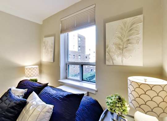 a living room with a blue couch and a window