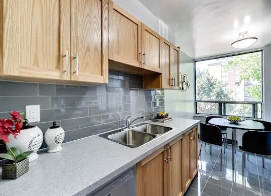 A kitchen with wooden cabinets and a grey countertop.