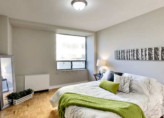 A bedroom with a large bed and a window.
