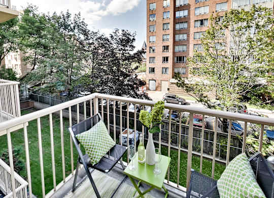 a balcony with two chairs and a table on it