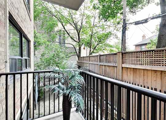 the balcony has a view of the yard and the trees