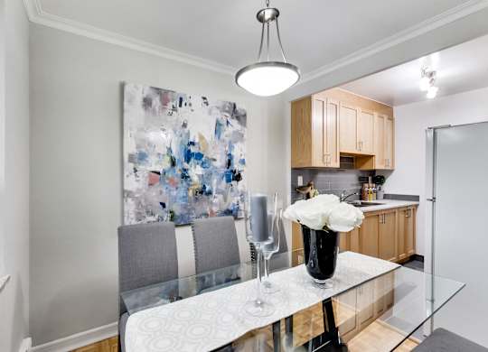 a kitchen and dining room with a white counter top and a glass table
