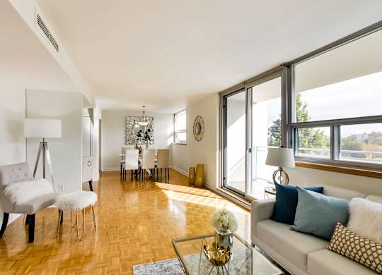 A living room with a white couch and a wooden floor.