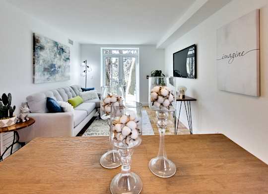 a living room with a wooden table with glass vases and a couch