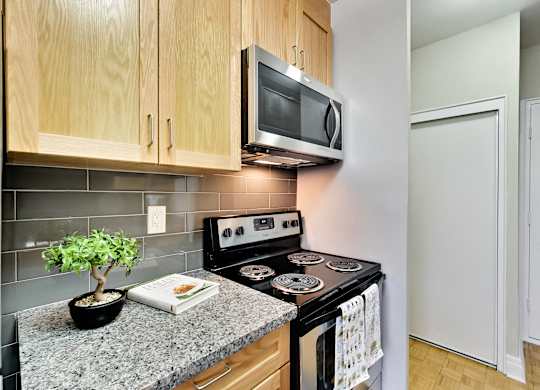 an updated kitchen with granite countertops and a stove and microwave
