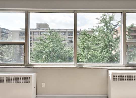 a room with a large window and a view of trees