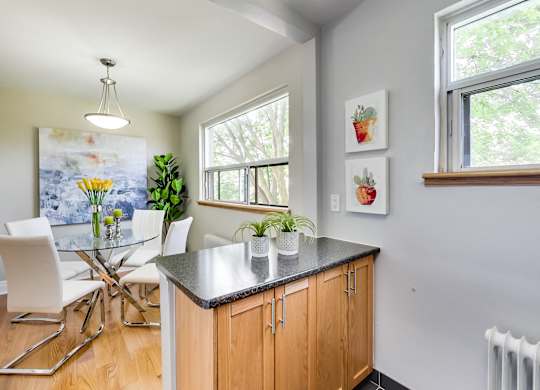 A kitchen with a table and chairs and a painting on the wall.