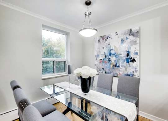 a dining room with a glass table and chairs
