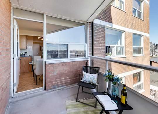 A balcony with a table and chairs overlooking a building.