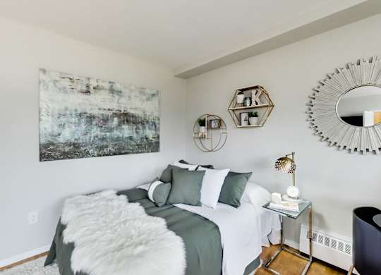 A bedroom with a large bed and a painting on the wall.