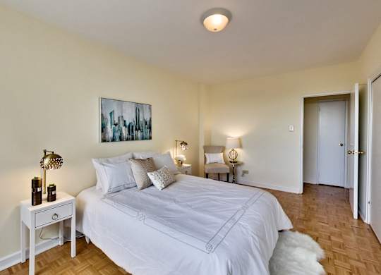 A bedroom with a large bed and a painting on the wall.