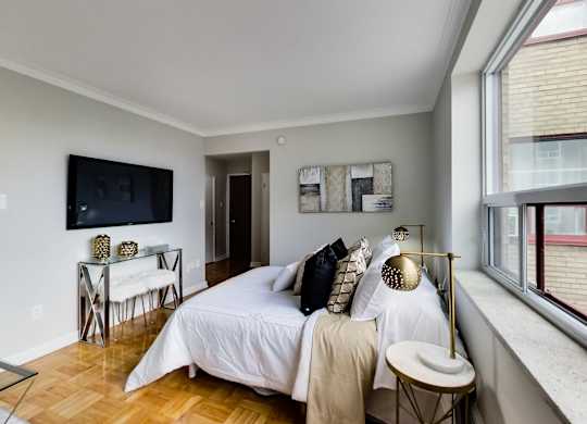 a bedroom with a bed and a tv on the wall