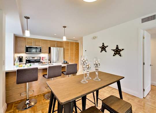 a kitchen and dining room with a wooden table and chairs