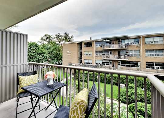 a balcony with a table and chairs on it