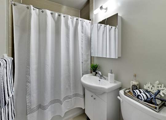 a bathroom with a shower and a sink and a toilet