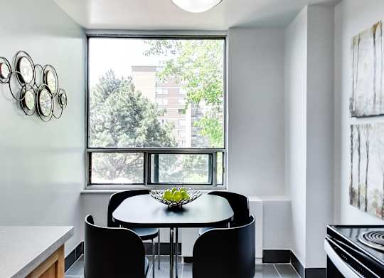 A dining room with a table and chairs.