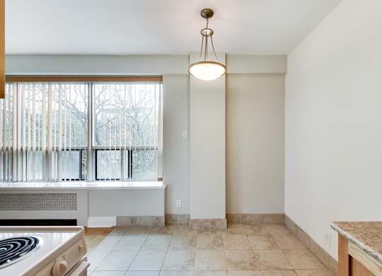 an empty kitchen with a window and a stove and a counter top