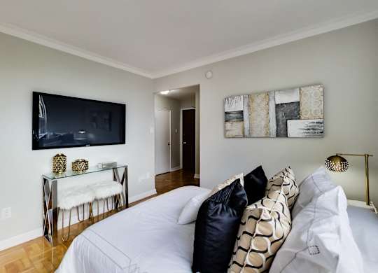a bedroom with a large bed and a tv on the wall