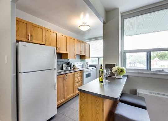 a kitchen with white appliances and wooden cabinets and a counter top