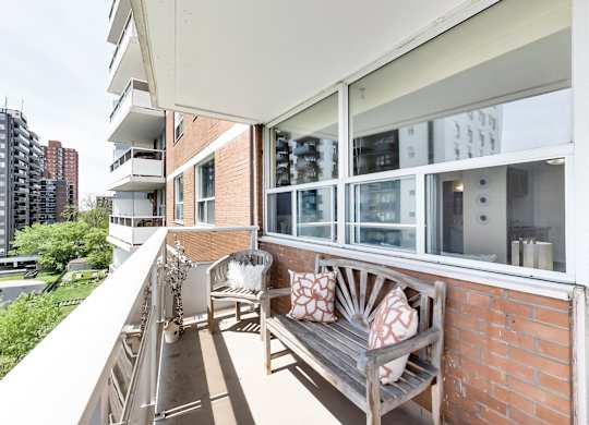 A balcony with a bench and pillows on it.